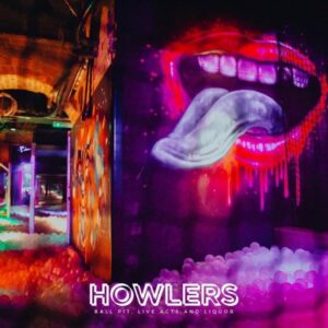 the howlers newcastle ball pool filled with white balls, graffiti on the wall of bright red lips with a tongue sticking out.