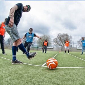 2 players, heading towards a football. both wearing beer goggles and struggling to connect with the ball.